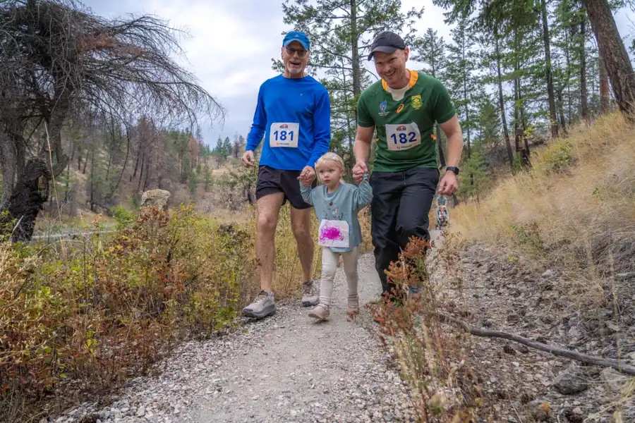 A dad running the finish with two children